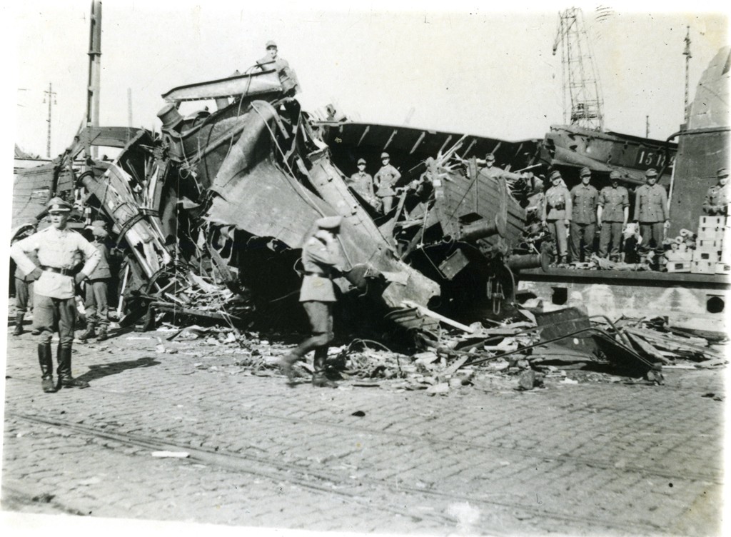 Tyske officerer besigtiger skaderne. Billedet viser skaderne efter at prammen ved eksplosionen er slynget ud ad havnebassinet og er landet i en godsvogn. (Besættelsesmuseet)