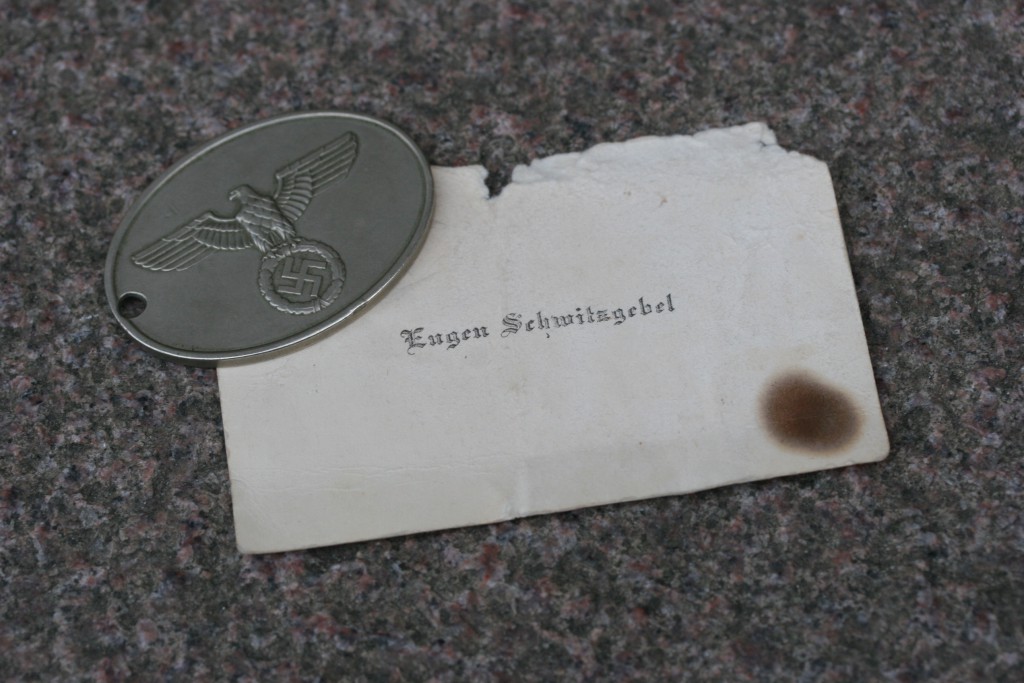 Tysk politiskilt og let forkullet  visitkort tilhørende Gestapo-chefen fundet i ruinerne efter luftangrebet. (Besættelsesmuseets samling) 