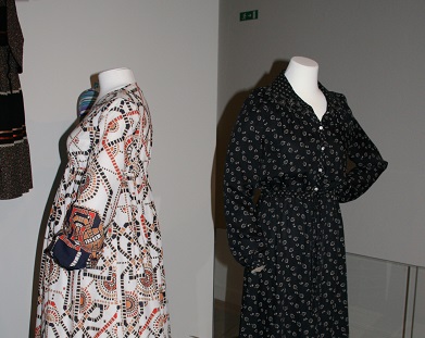 To damer prøver tøj i udstillingens butik.
