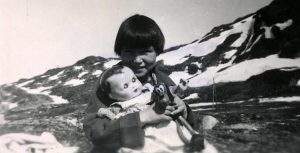 Helene hjemme i Grønland efter opholdet i Danmark. Her ses hun igen med dukke Tove. 
