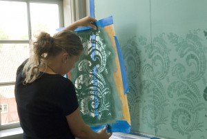 Anne Mette arbejder med skabelonmaleriet i Fruens Kabinet